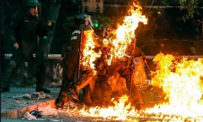 Las impactantes imágenes de carabineros envueltos en llamas tras ser atacados con bombas molotov en Chile